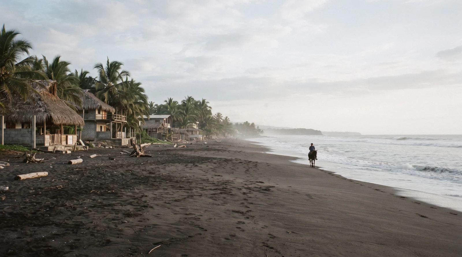 Monterrico Guatemala black-sand beach with the turtle hatchery fence and the Pacific surf behind