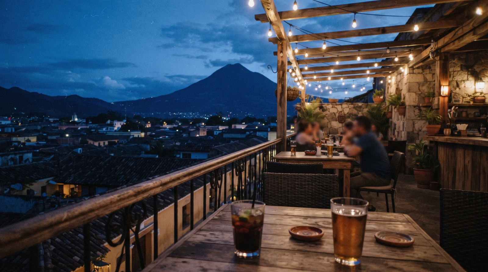 A colonial street in Antigua Guatemala at night with warm bar light spilling onto cobblestones