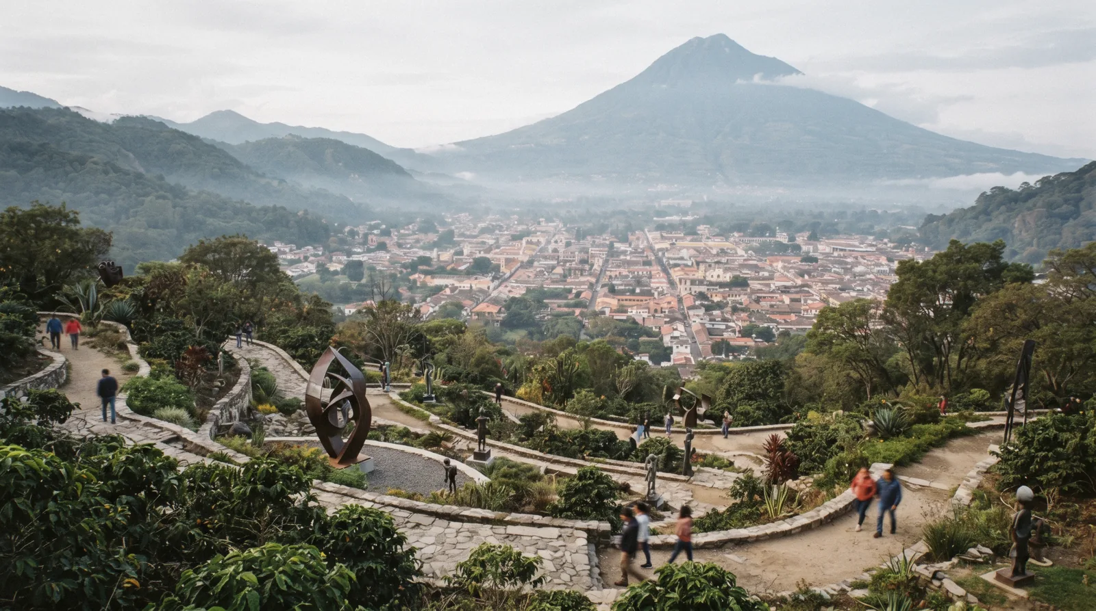 The hillside terraces of the Santo Domingo del Cerro cultural park above Antigua Guatemala with sculptures among coffee terraces and the valley below in morning haze