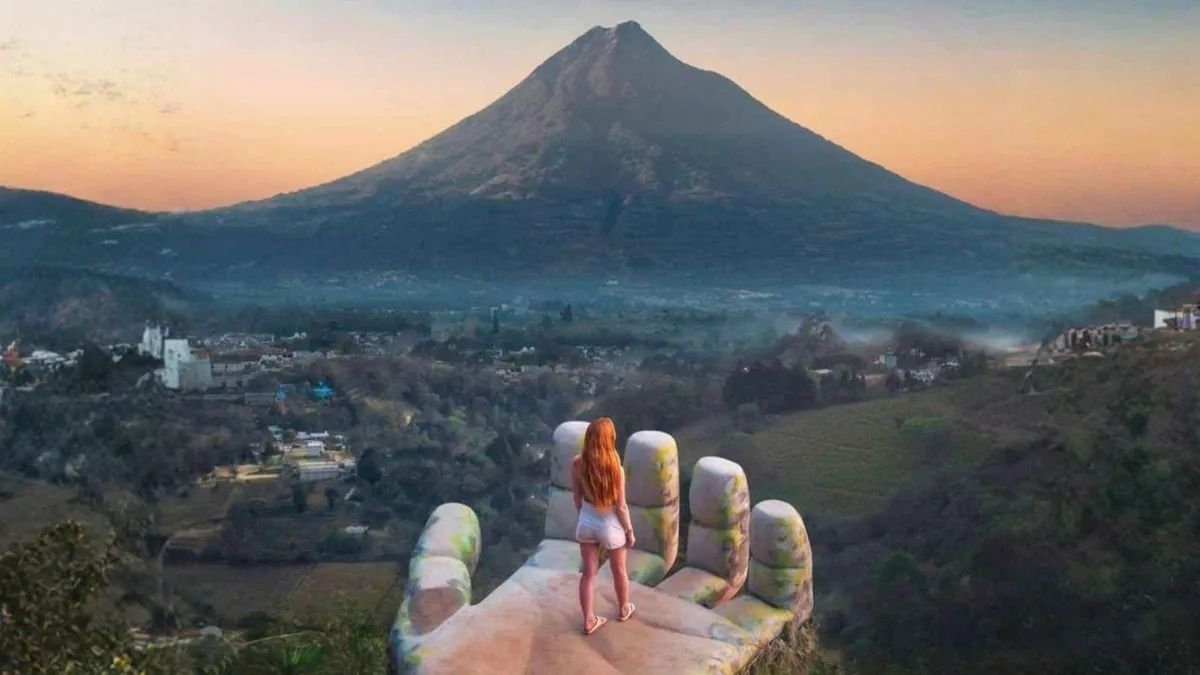 Visitor at the Hobbitenango entrance arch with the fog-covered valley behind, Antigua Guatemala
