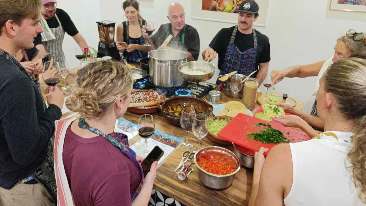 Cooking class participant grinding pepian ingredients in an Antigua Guatemala kitchen