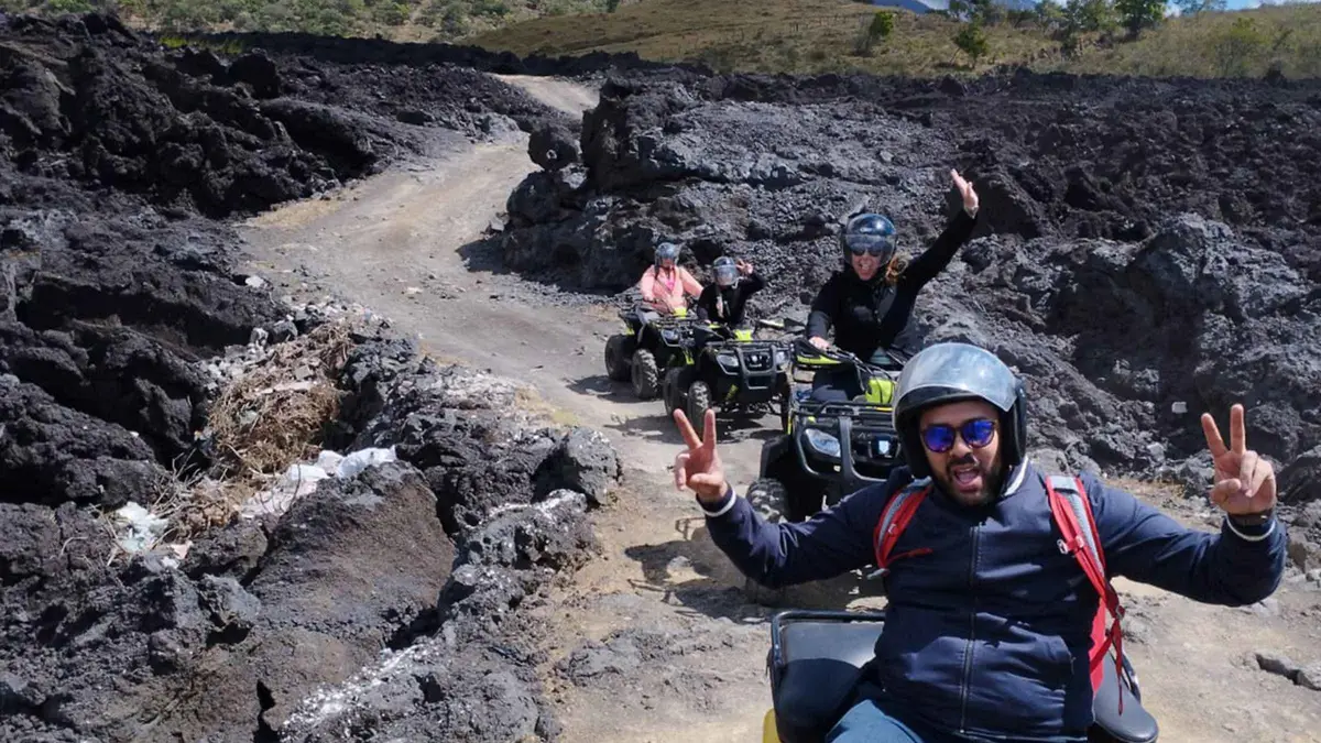 Rider on an ATV on the dusty trail below Pacaya volcano with steam vents, Pacaya ATV adventure from Antigua